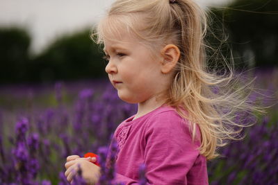 Close-up of girl amidst flowers on field