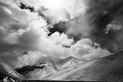 Scenic view of mountain range against cloudy sky