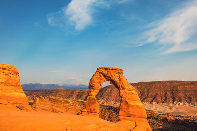 Rock formations on landscape against cloudy sky