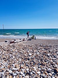 Full length of man standing at beach against clear sky