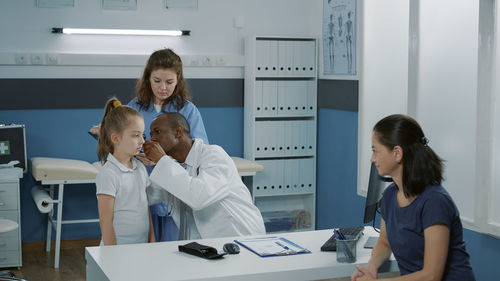 Side view of doctor examining patient in office