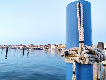 Wooden post in sea against clear sky
