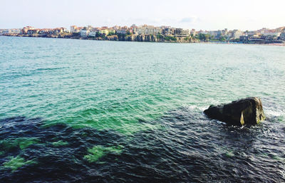 Scenic view of sea against sky in city