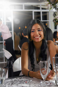 Portrait of smiling young woman at restaurant table