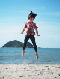 Full length of girl jumping at beach