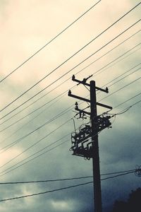 Low angle view of silhouette electricity pylon against sky