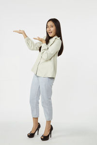 Portrait of smiling young woman against white background