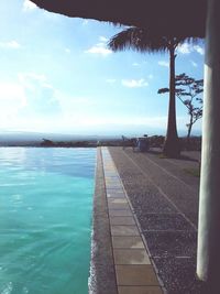 Swimming pool by sea against sky