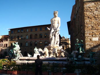 Low angle view of statue against buildings in city