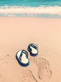 High angle view of shoes on sand at beach