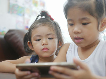 Siblings using digital tablet on table