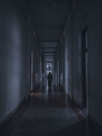 Rear view of man walking in tunnel