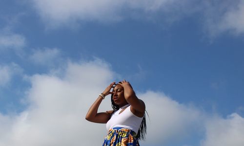 Low angle view of woman standing against sky