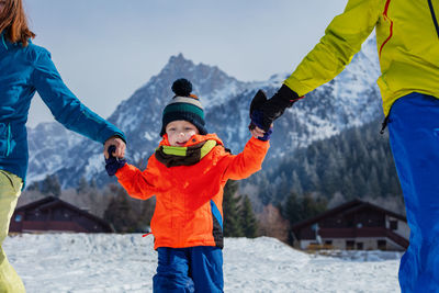 Rear view of boy standing on snow