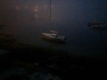 Abandoned boats moored at night