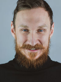 Portrait of smiling handsome bearded man. confident brutal hipster guy with red beard and mustache.