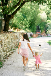 Rear view of women walking on footpath