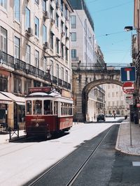 Tram on street amidst buildings in city