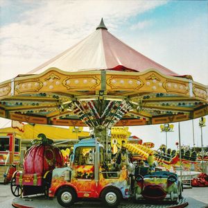 Carousel in amusement park against sky