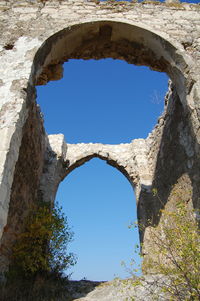 Low angle view of old ruin seen through hole