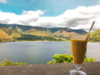 View of drink with lake against cloudy sky