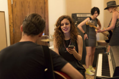 Young woman using smart phone while sitting in office