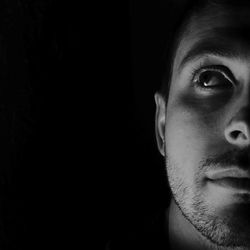 Cropped image of thoughtful man against black background