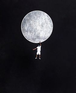 Full length of man holding moon against sky at night