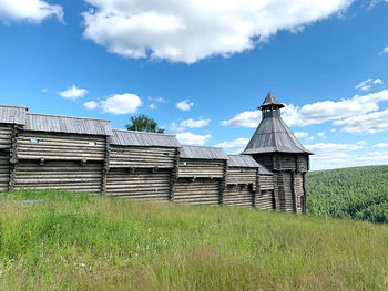 Traditional windmill on field against sky