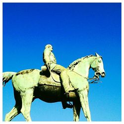 Low angle view of statue against clear blue sky