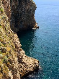 High angle view of rock formation by sea against sky