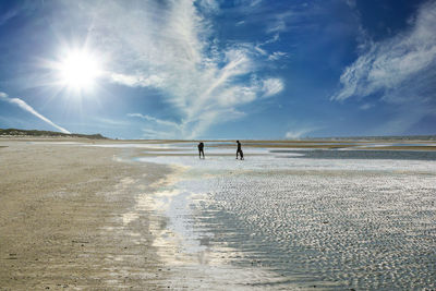 People walking on land against sky