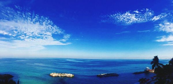 Panoramic view of sea against blue sky