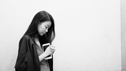 Young woman standing against white background