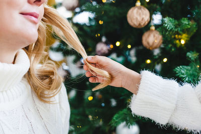 Midsection of woman with christmas tree