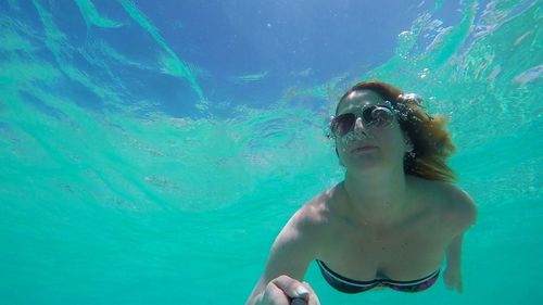 Portrait of young woman swimming undersea