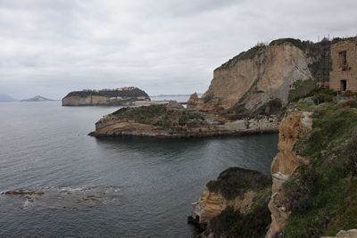 Rock formations by sea against sky