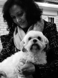 Portrait of woman with dog sitting at home