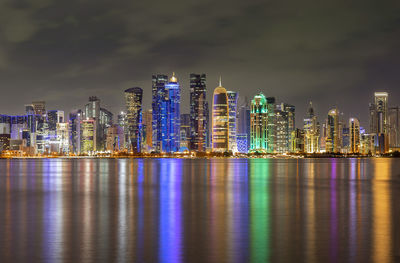 Illuminated buildings against sky at night