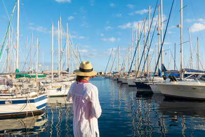 Young woman looking at the sea at the marina in puerto de mogan, gran canaria, canary islands, spain