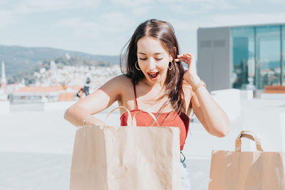 Portrait of young woman standing against sky