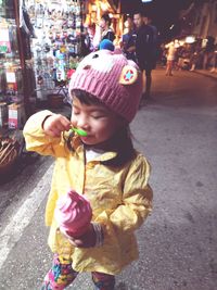 Cute girl holding ice cream on street in city