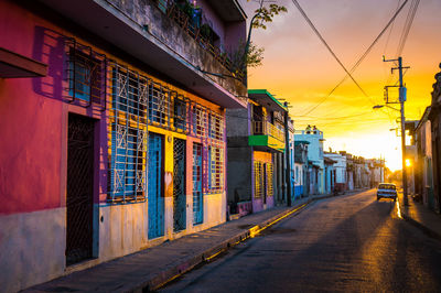 Illuminated street amidst buildings in city at night