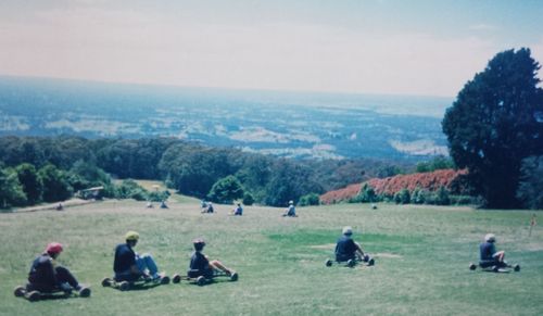 People relaxing on grassy field