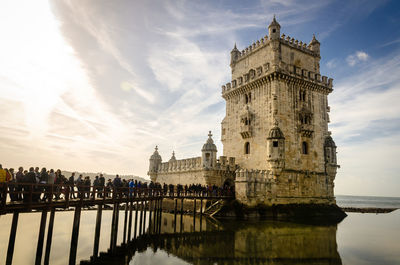 People outside belem tower on footbridge