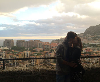 Couple kissing against cityscape