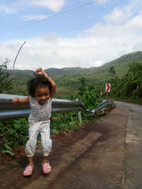 Full length of girl standing on mountain against sky