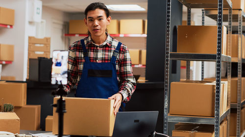 Portrait of young man standing in creative office