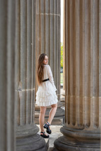 Rear view of woman standing against curtain