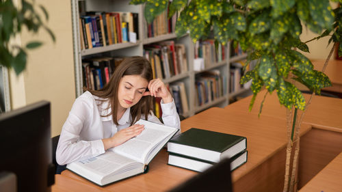 Portrait of young woman using laptop at office